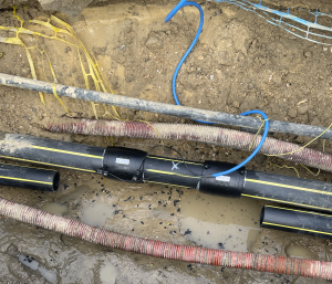 Cette équipe d'entreprise spécialisée est en train de réparer une fuite de canalisation de gaz. Dans le sol sur du PEHD diamètre 110 mm sur un réseau de gaz naturel., Après avoir découpé la canalisation dans le sol et fait toute la préparation méthodique pour l'électro soudage, ils ont positionné deux manchons de chaque côté de la canalisation, ils sont en train de procéder à l'assemblage et le soudage des raccords en PEHD GAZ DANS LE SOL.